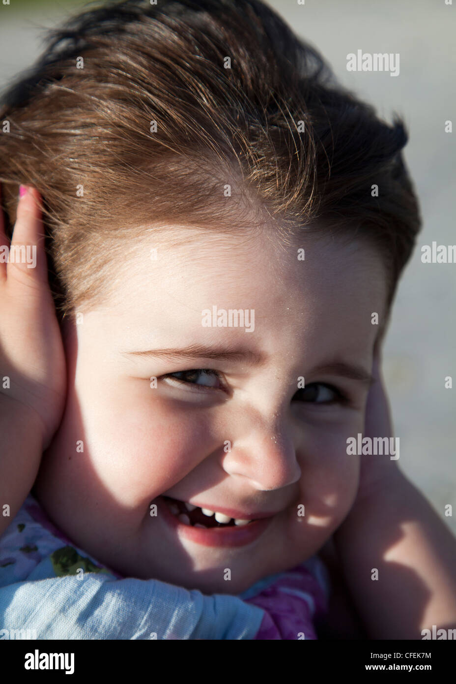 Girl covering ears from wind Stock Photo Alamy