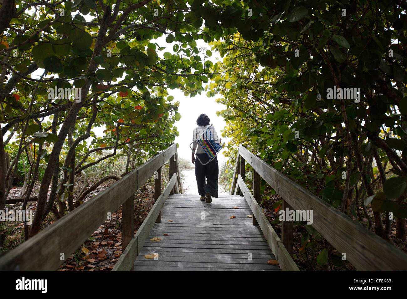 A woman walks to the beach, Naples, Florida Stock Photo