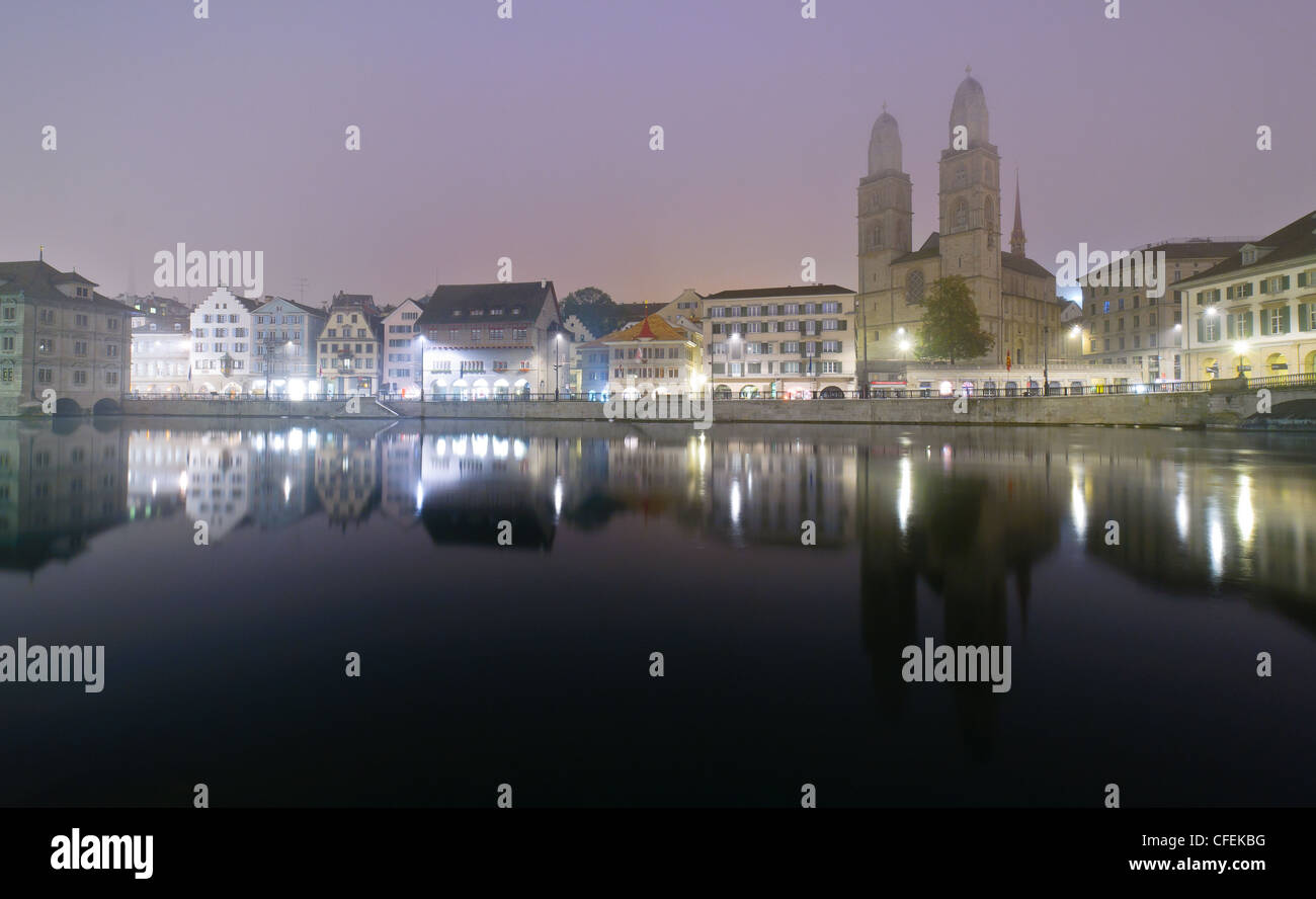 View of Zurich and old city center reflecting in the river Limmat at night. Stock Photo