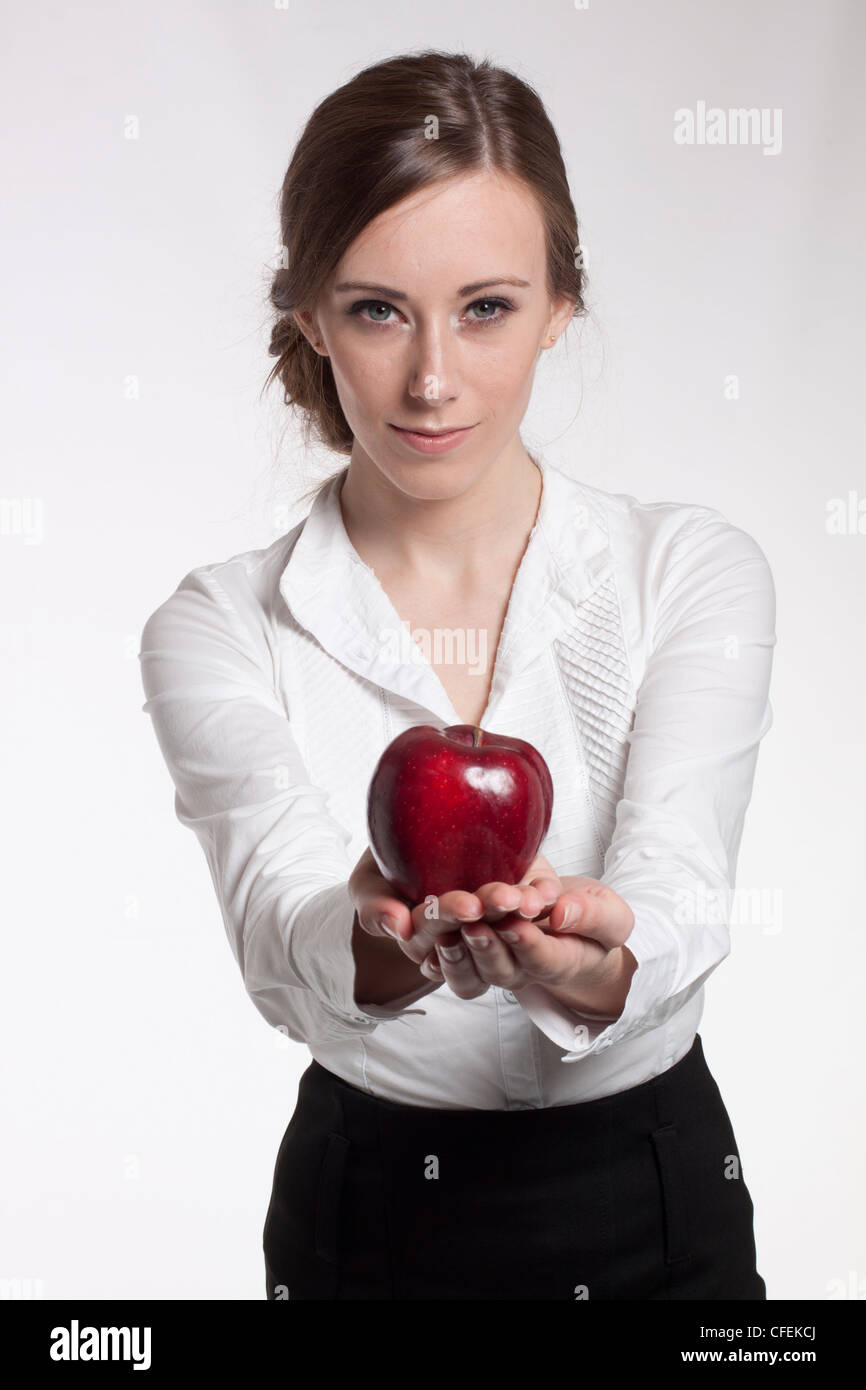 Young female offering a red apple Stock Photo