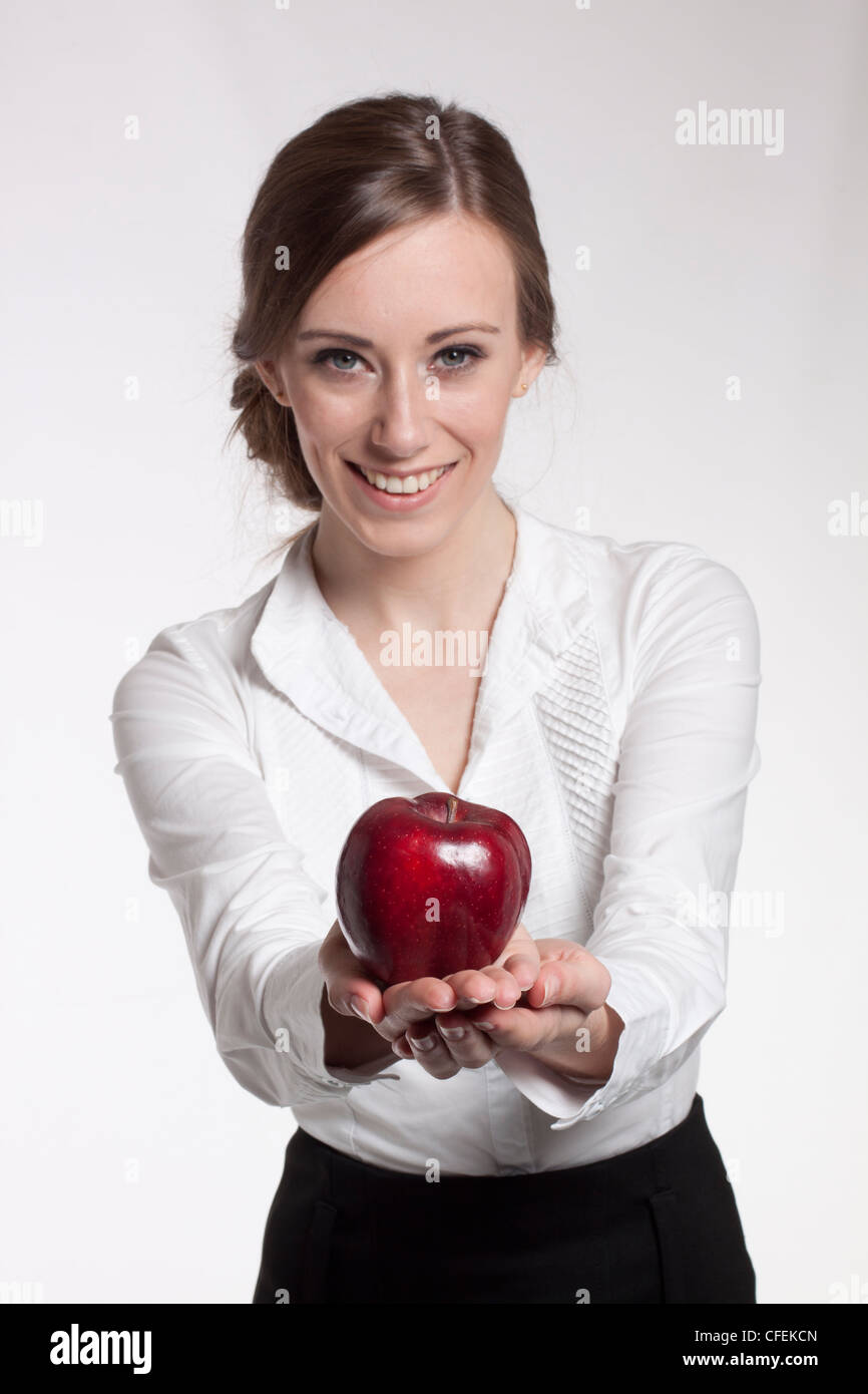 Young female presenting a red apple Stock Photo