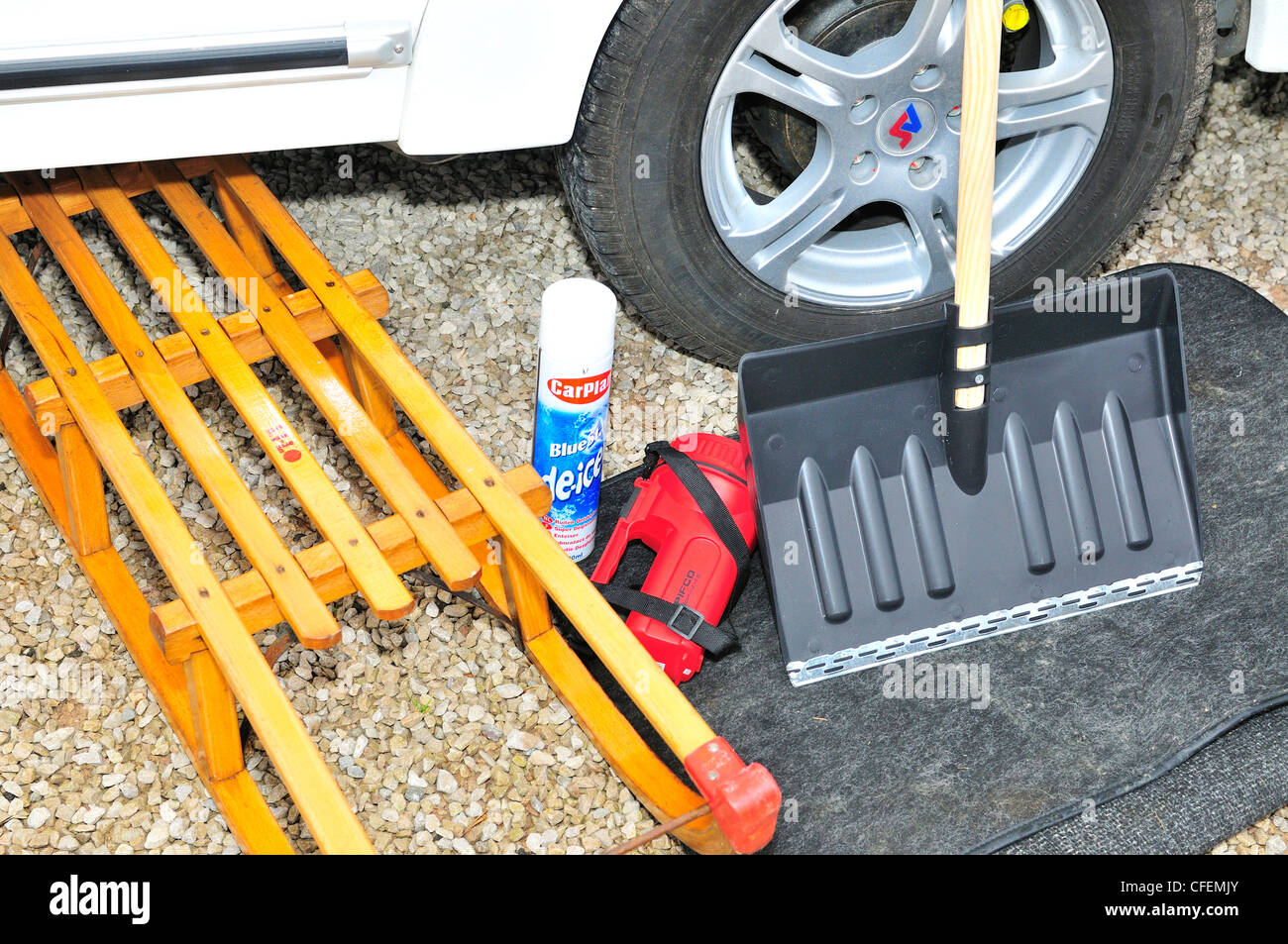 Snow toboggan ,snow shovel, deicer torch mat for under tyres  next to caravan as winter preparation for forthcoming snowfall, Lancashire, England, UK Stock Photo