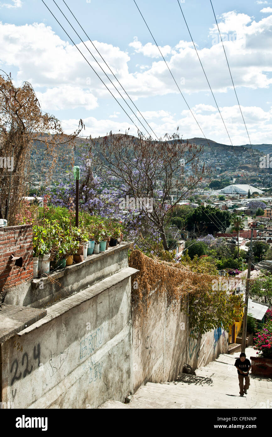 steep hillside pedestrian street with view of roof gardens & distant panorama of Oaxaca looking south on beautiful spring day Stock Photo