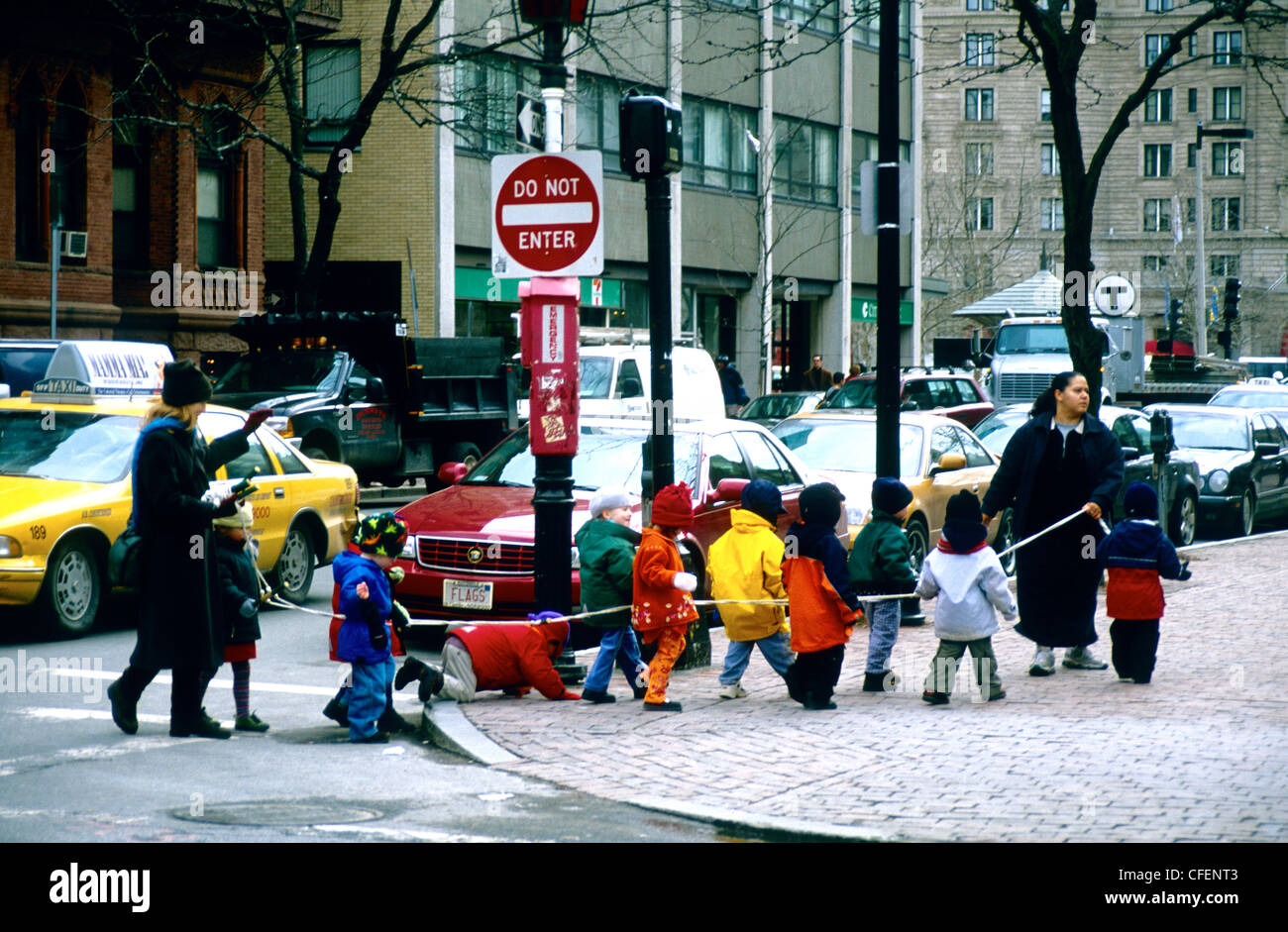 Kids on a rope -Boston children are shepparded in a city street holding a rope, Boston Mass USA Stock Photo