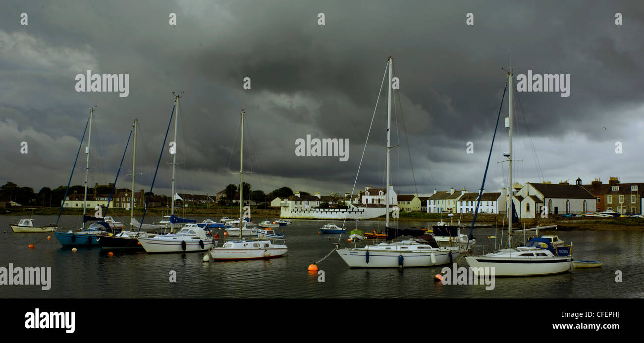 Sailing boats yachts take shelter in the harbour at Isle of Whithorn, Newton Stewart, Dumfries and Galloway, Scotland as storm clouds gather overhead Stock Photo