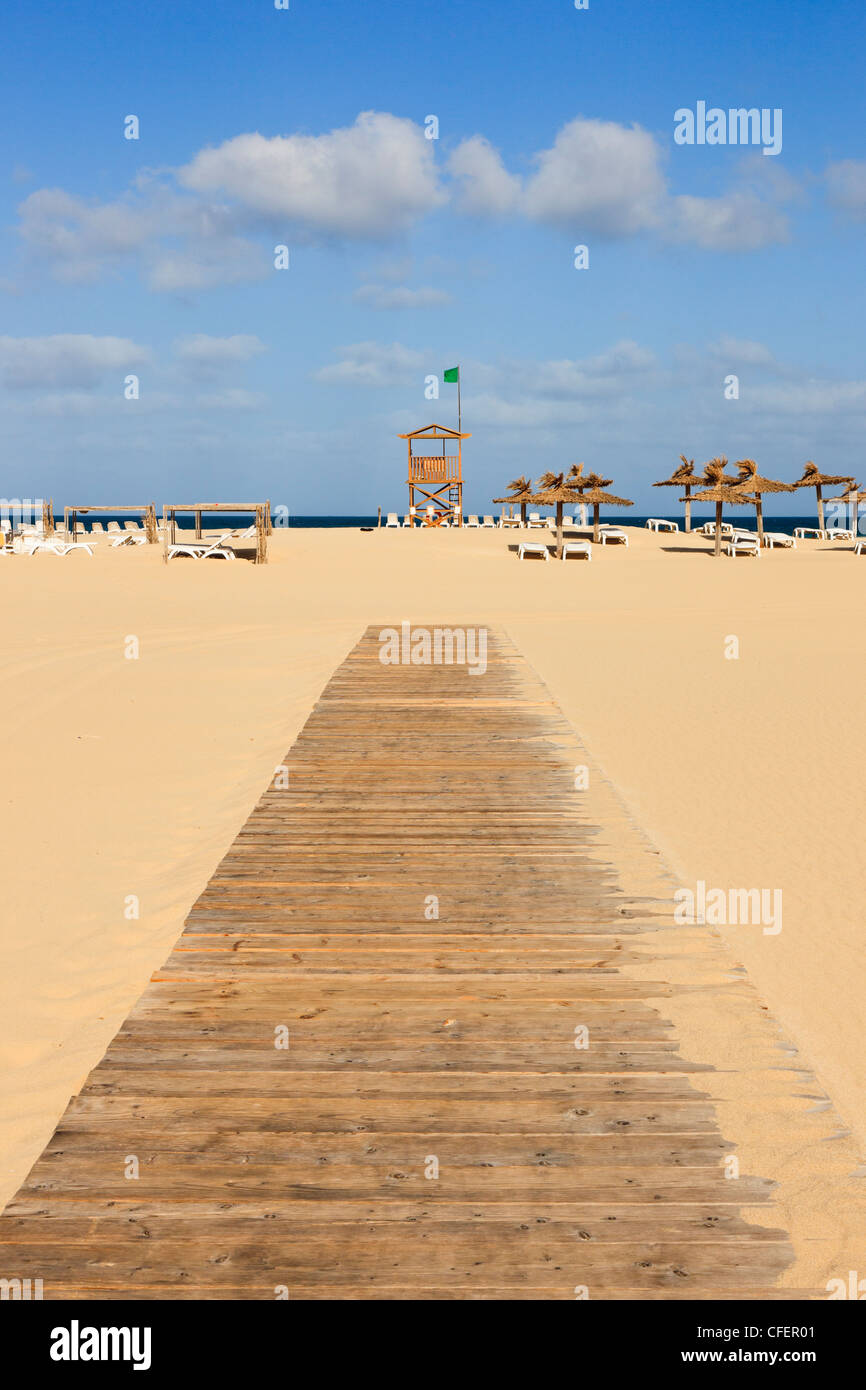 Wooden walkway across sandy beach to coastguard lookout with green flag. Praia de Chaves, Rabil, Boa Vista, Cape Verde Islands Stock Photo