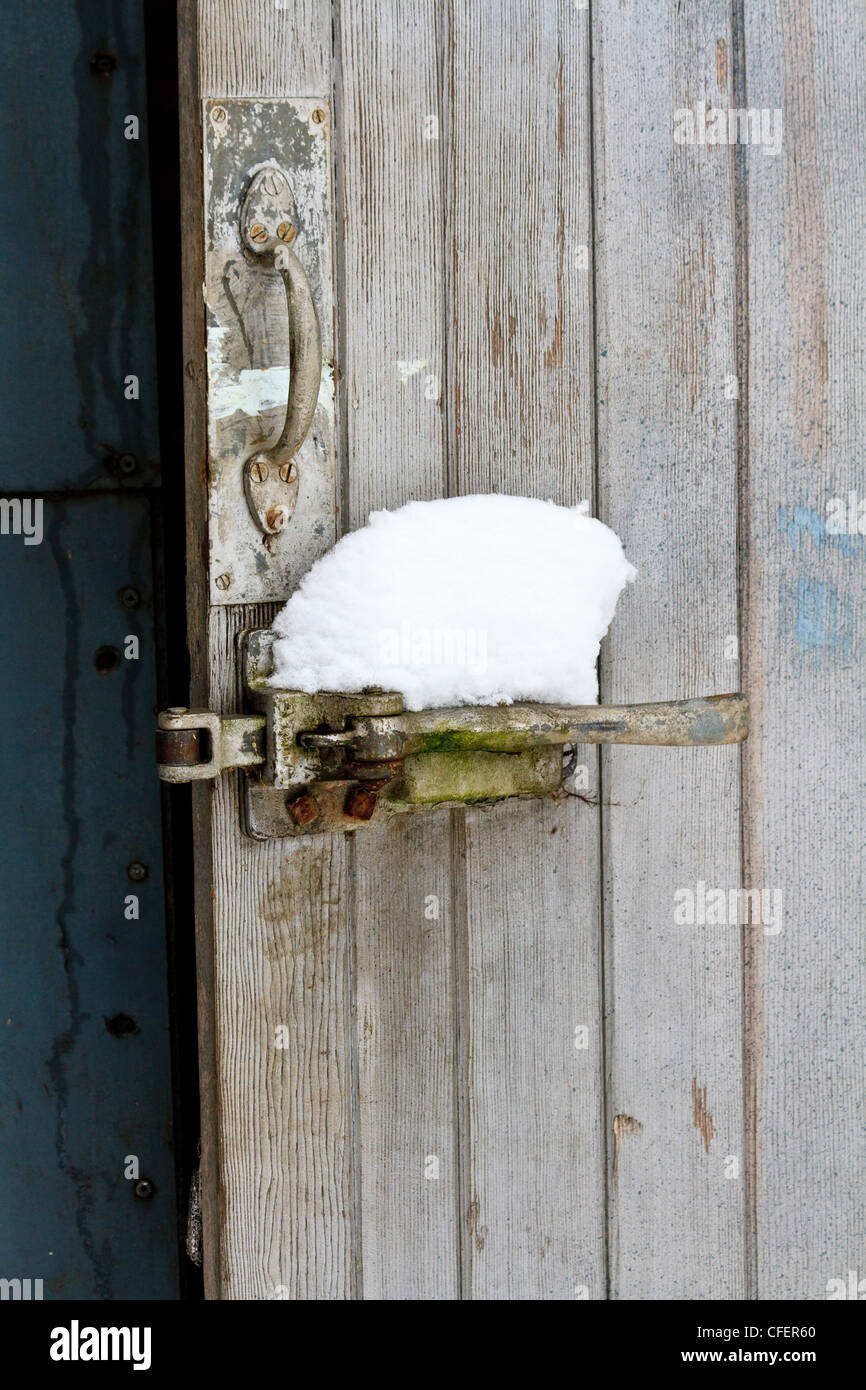 Wooden barn door with snow on the handle Stock Photo