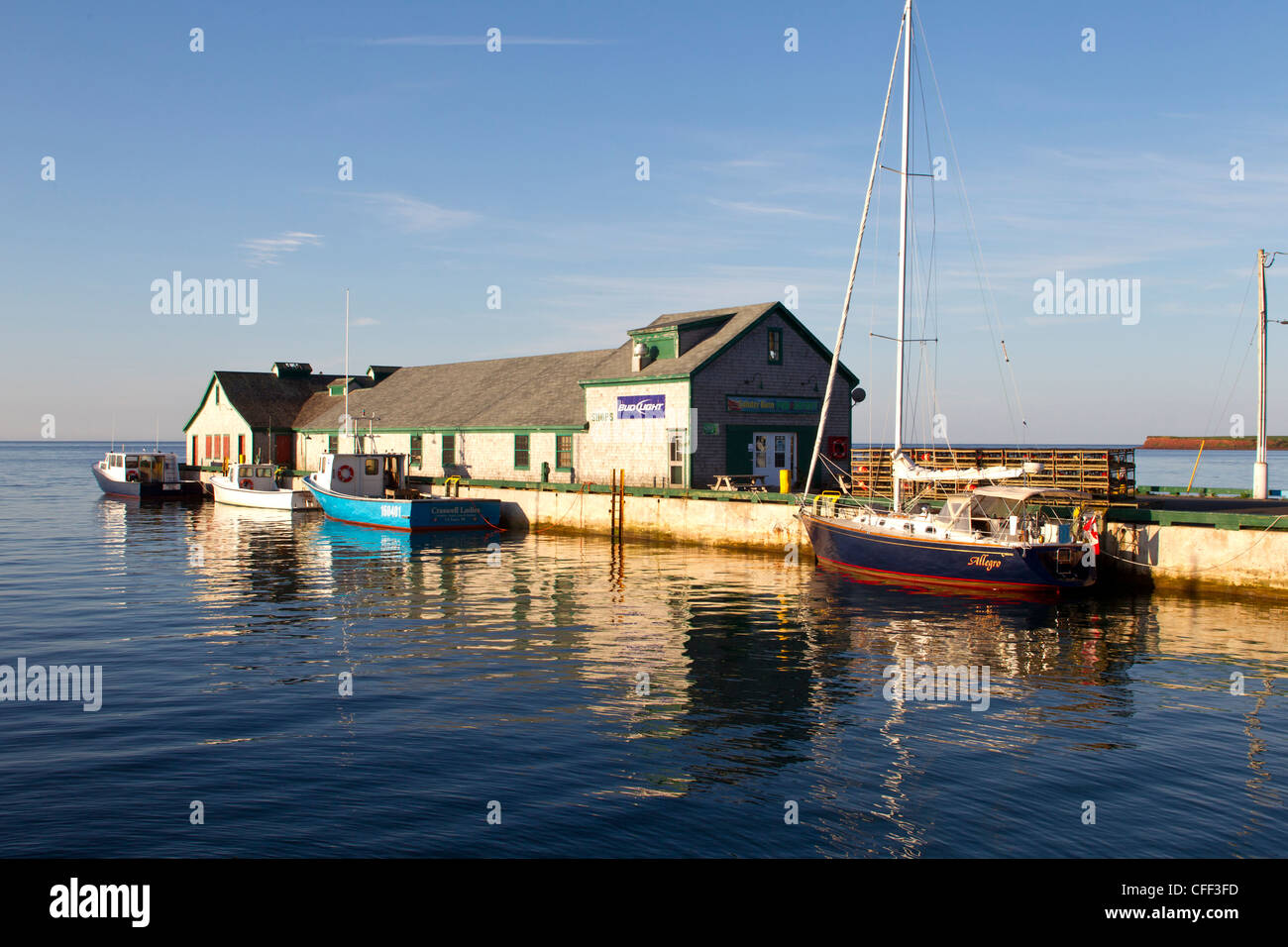 Fishing boats and sailboat tied up at wharf, Victoria, Prince Edward Island, Canada Stock Photo
