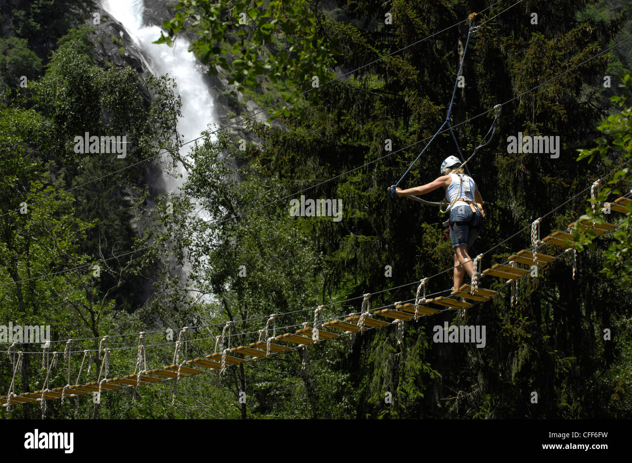 One person on suspension bridge at climbing park, Partschins waterfall in the background, Vinschgau, Alto Adige, South Tyrol, It Stock Photo