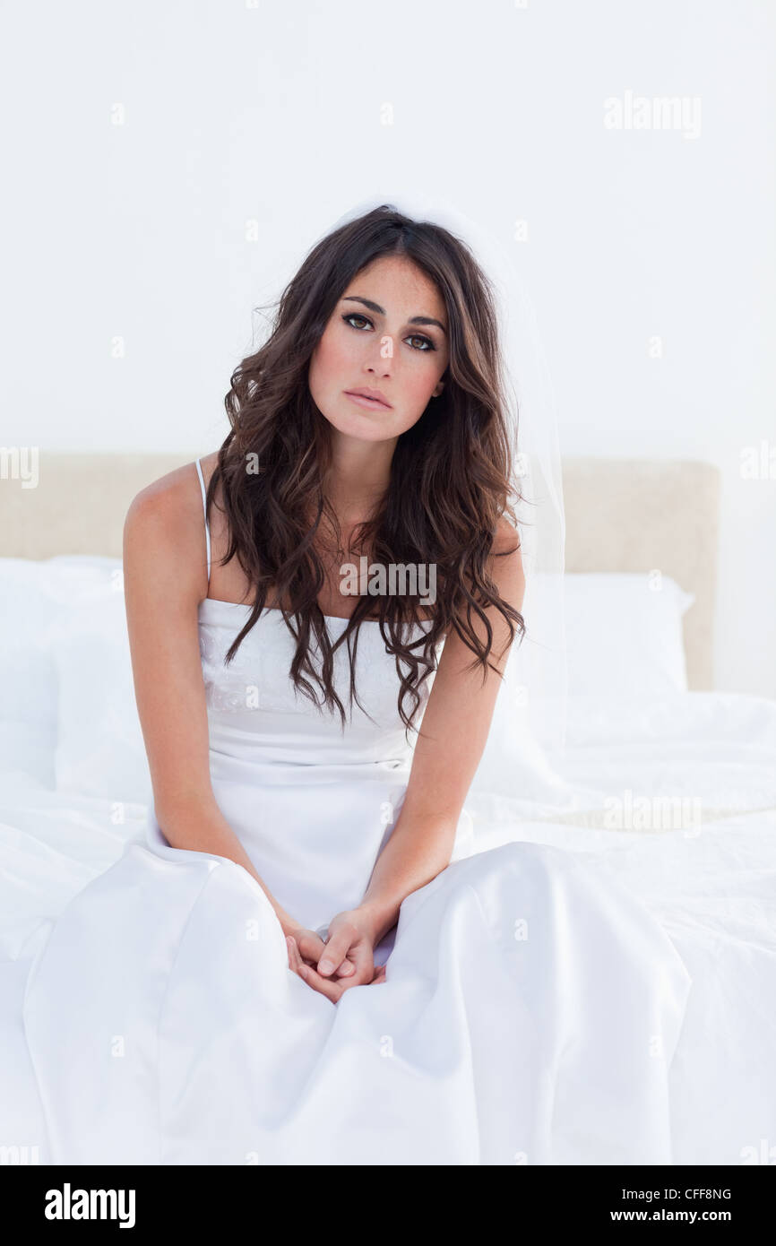Young betrothed sitting in her bed under her the cover Stock Photo