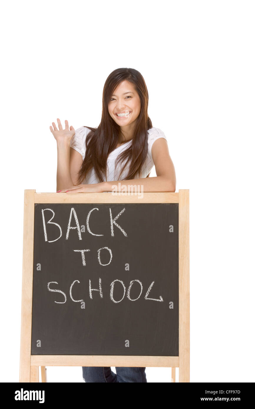 Friendly Asian High school girl student standing in jeans by blackboard that has text Back To School written by chalk Stock Photo