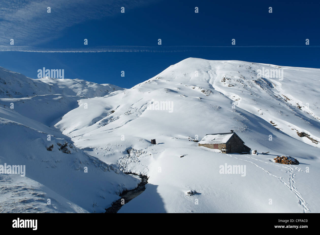 Mountain shelter in snowy mountain landscape near Col de Pause, Ariege, Pyrenees, France. Stock Photo