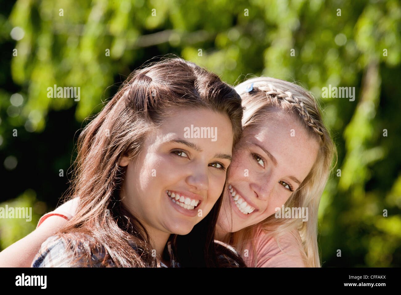 Young smiling girl wrapping her arms around her friend Stock Photo Alamy