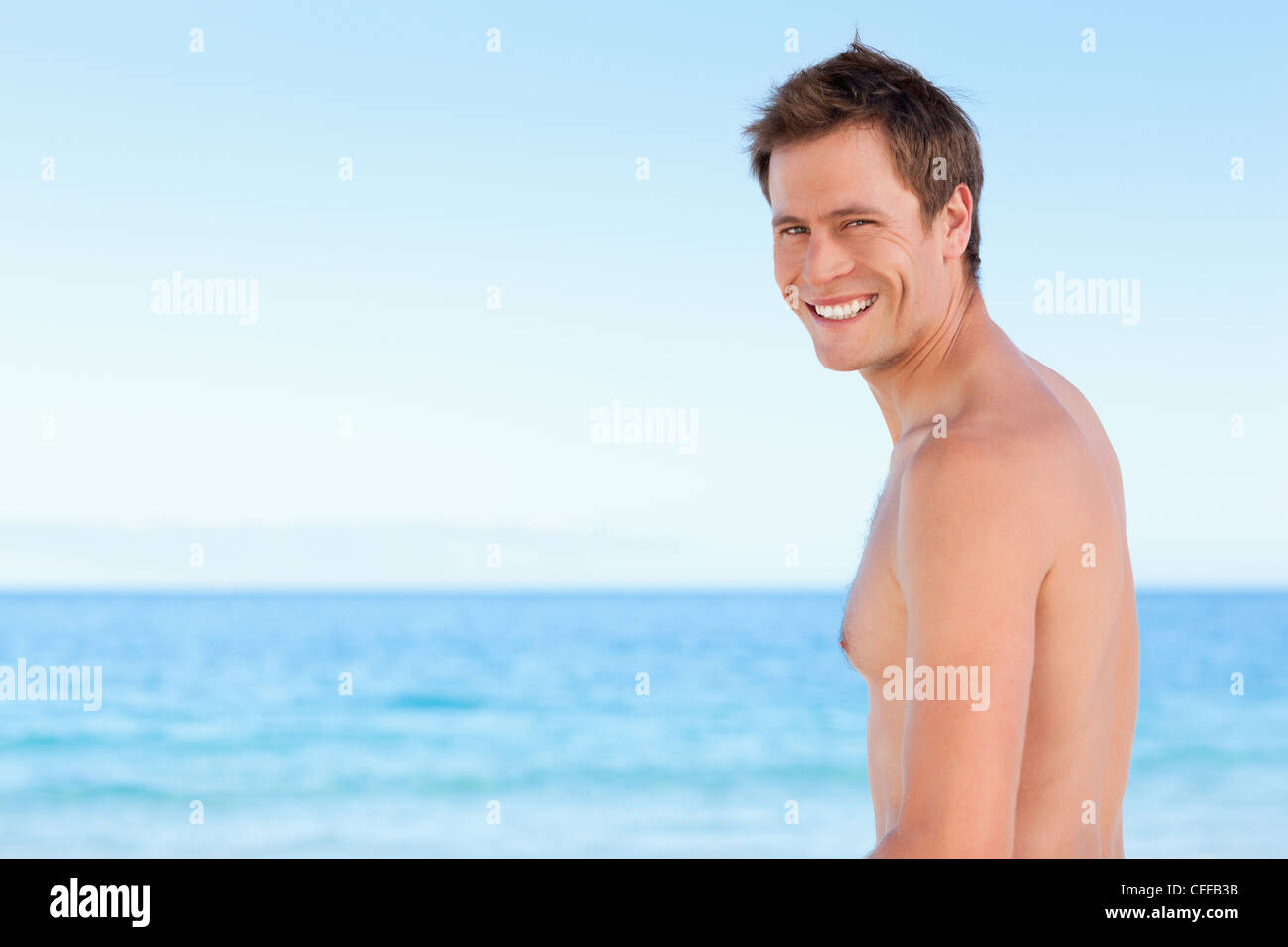 Side view of young man on the beach Stock Photo - Alamy