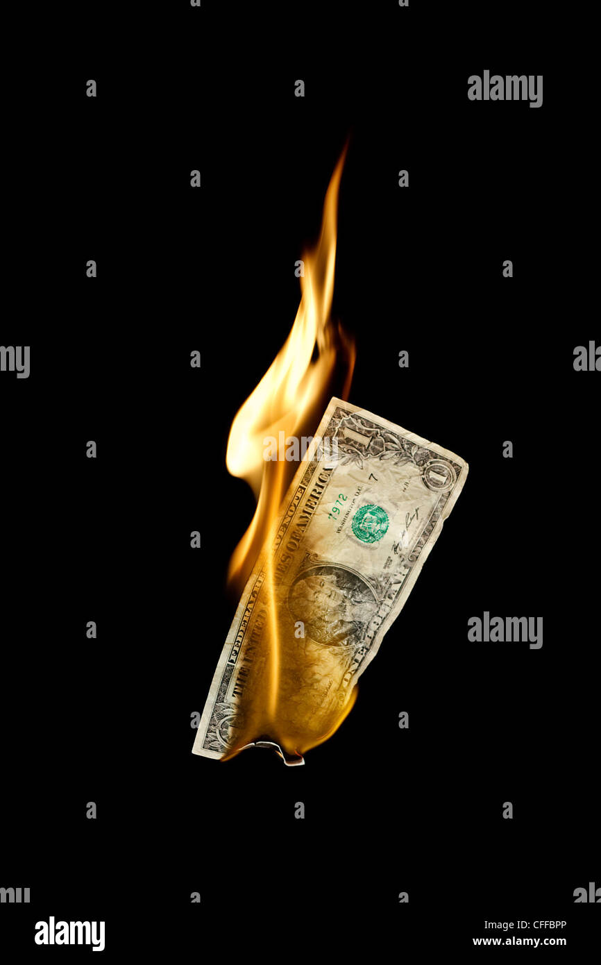 A burning dollar bill symbolizing careless money management Stock Photo