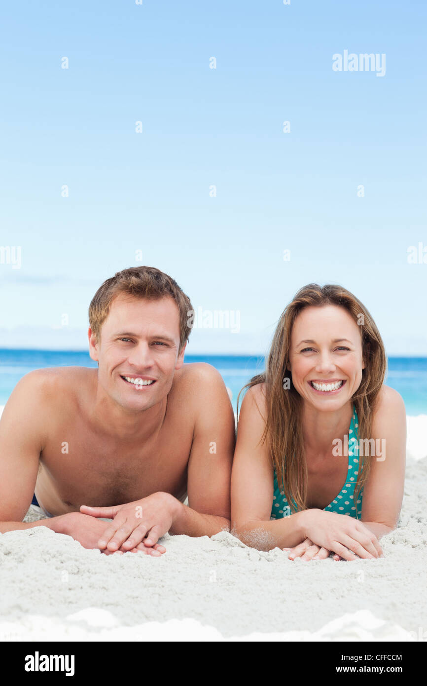 Smiling couple lying on the beach Stock Photo - Alamy