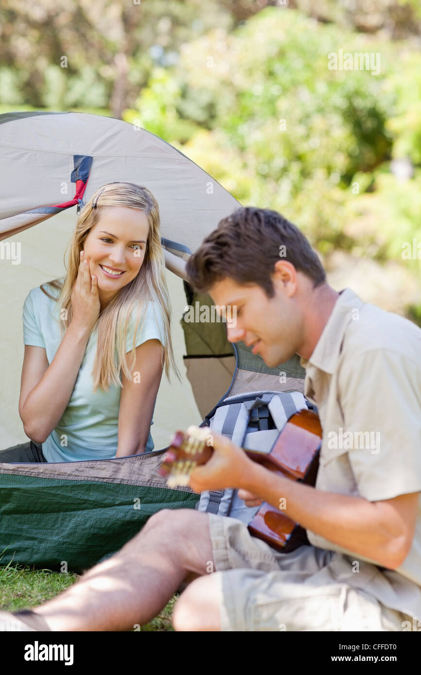 A woman falls in love even more with her boyfriend as he plays guitar Stock Photo
