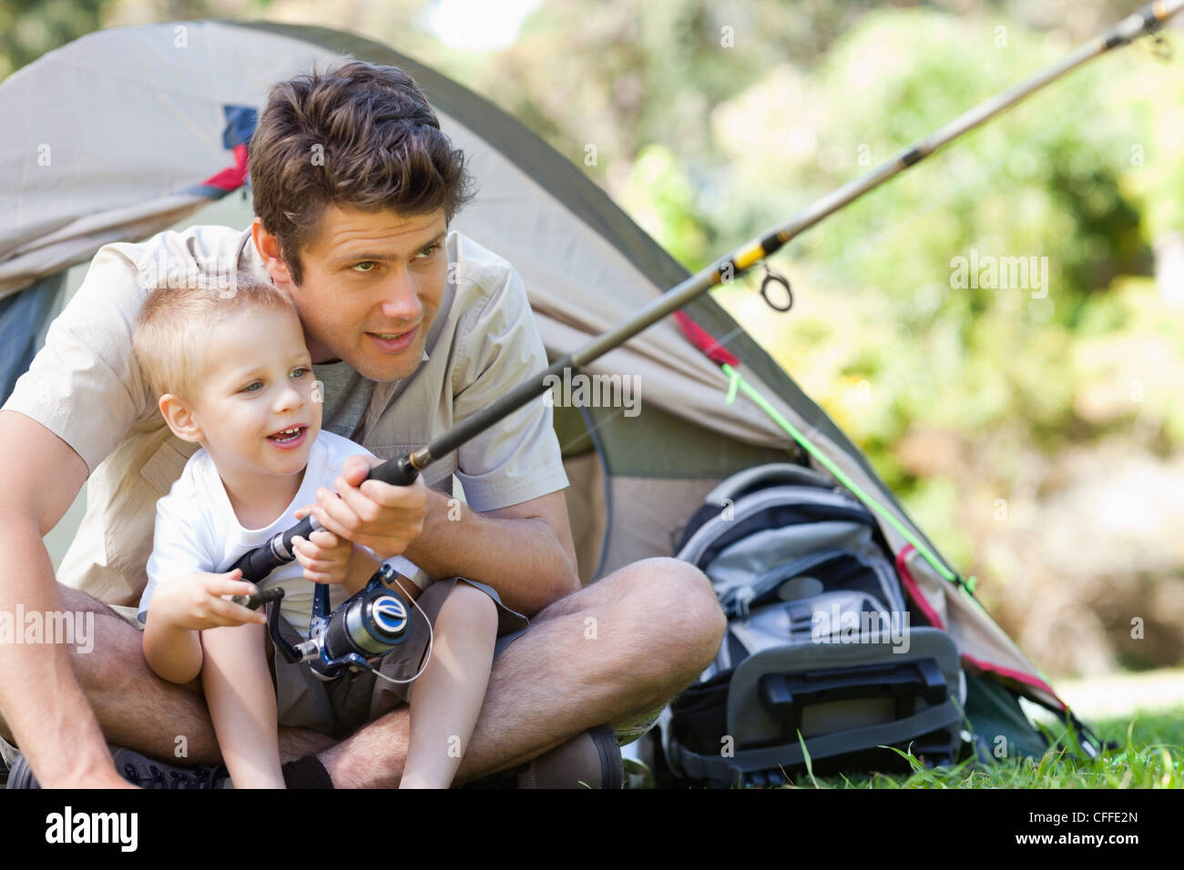 Dad helps his son learn how to fish Stock Photo - Alamy