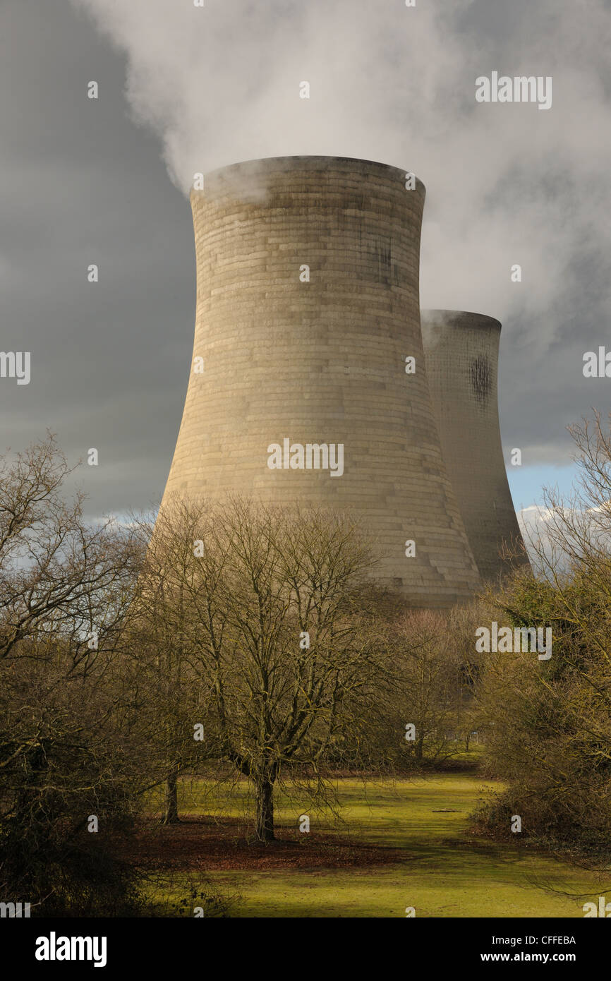 Giant cooling towers at an electricity generating station. White steam against a moody sky with