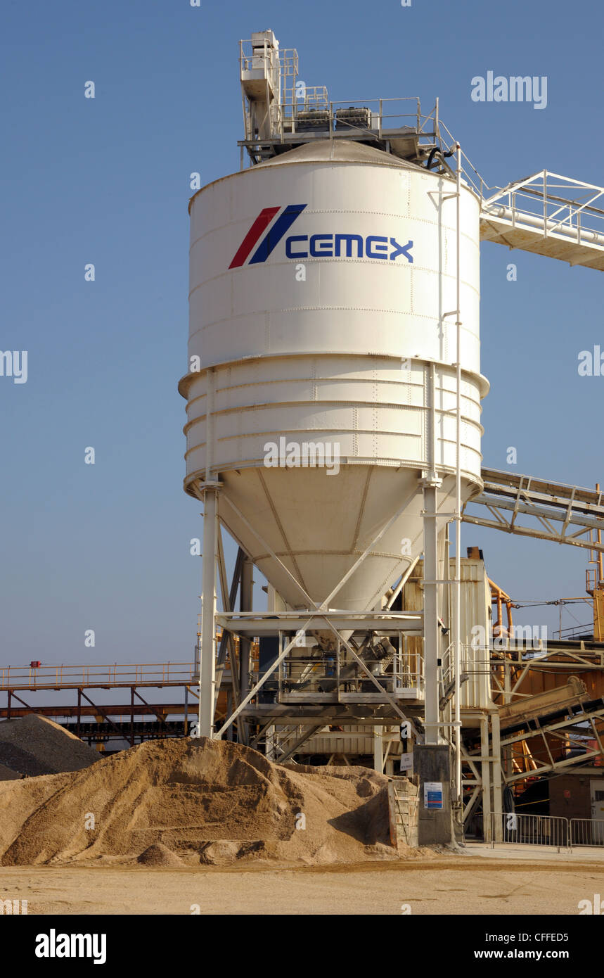 An industrial cement plant storage tank. Storage of sand and gravel, with conveyor belts in an industrial setting. Stock Photo