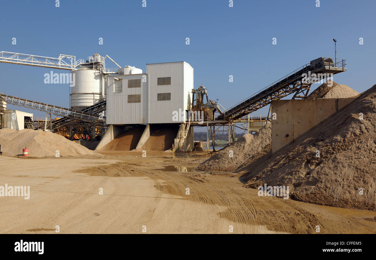 An industrial cement plant. Storage of sand and gravel, with conveyor belts in an industrial setting. Stock Photo