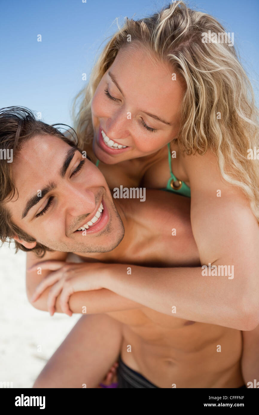 Smiling young man giving her girlfriend a piggy-back Stock Photo