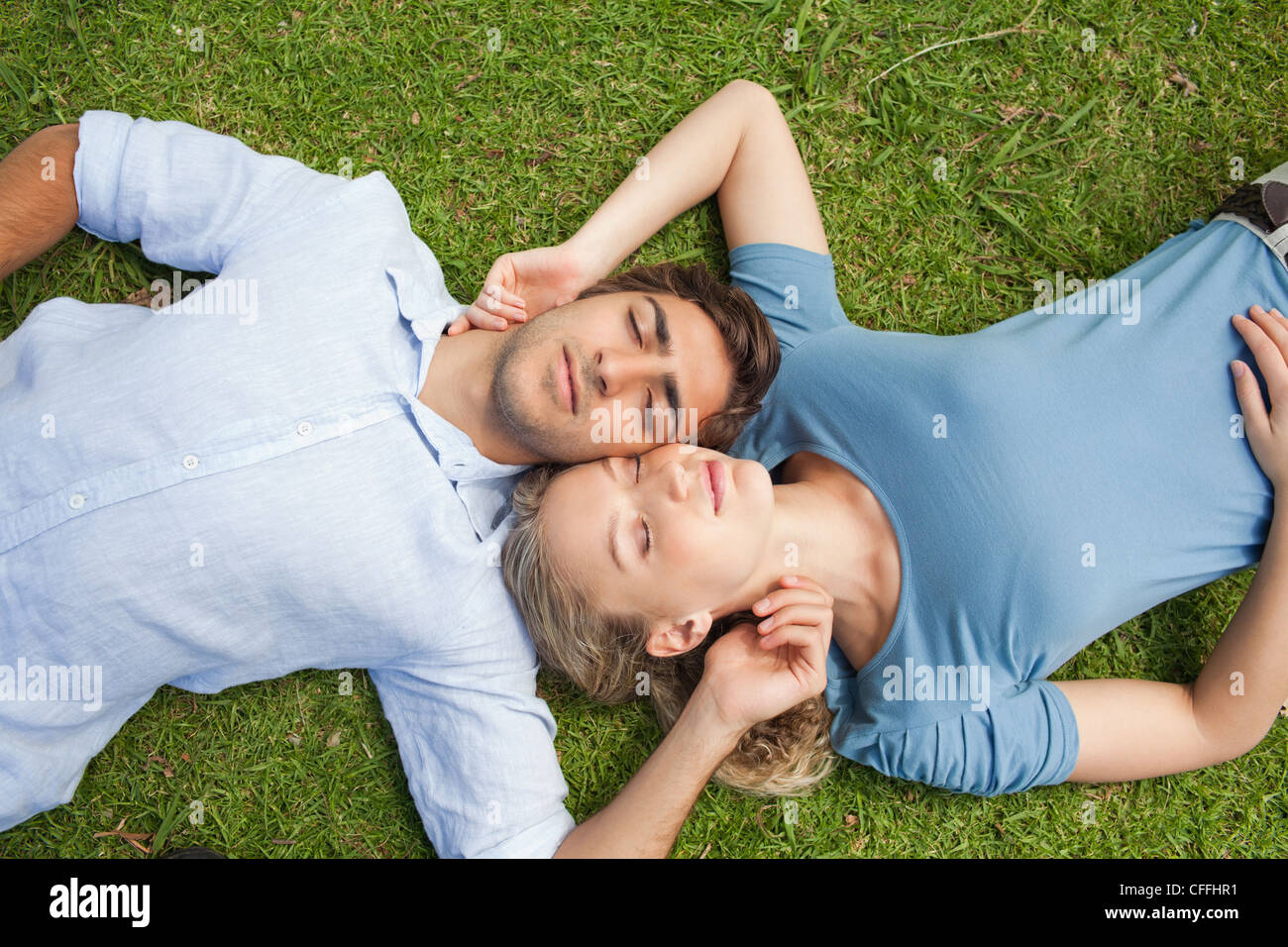 Couple relaxing on the lawn together Stock Photo - Alamy
