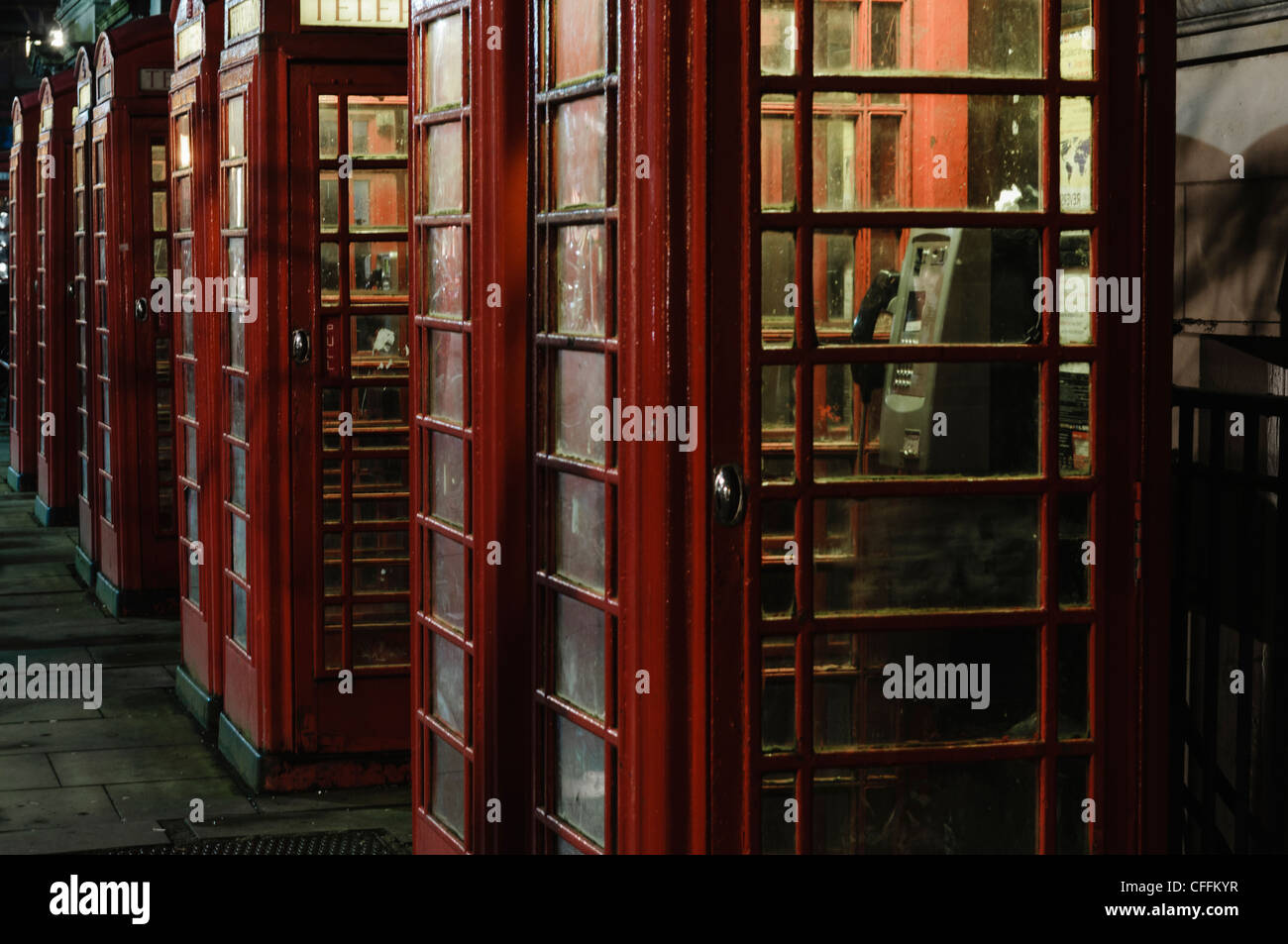 Row of red telephone boxes at night Stock Photo