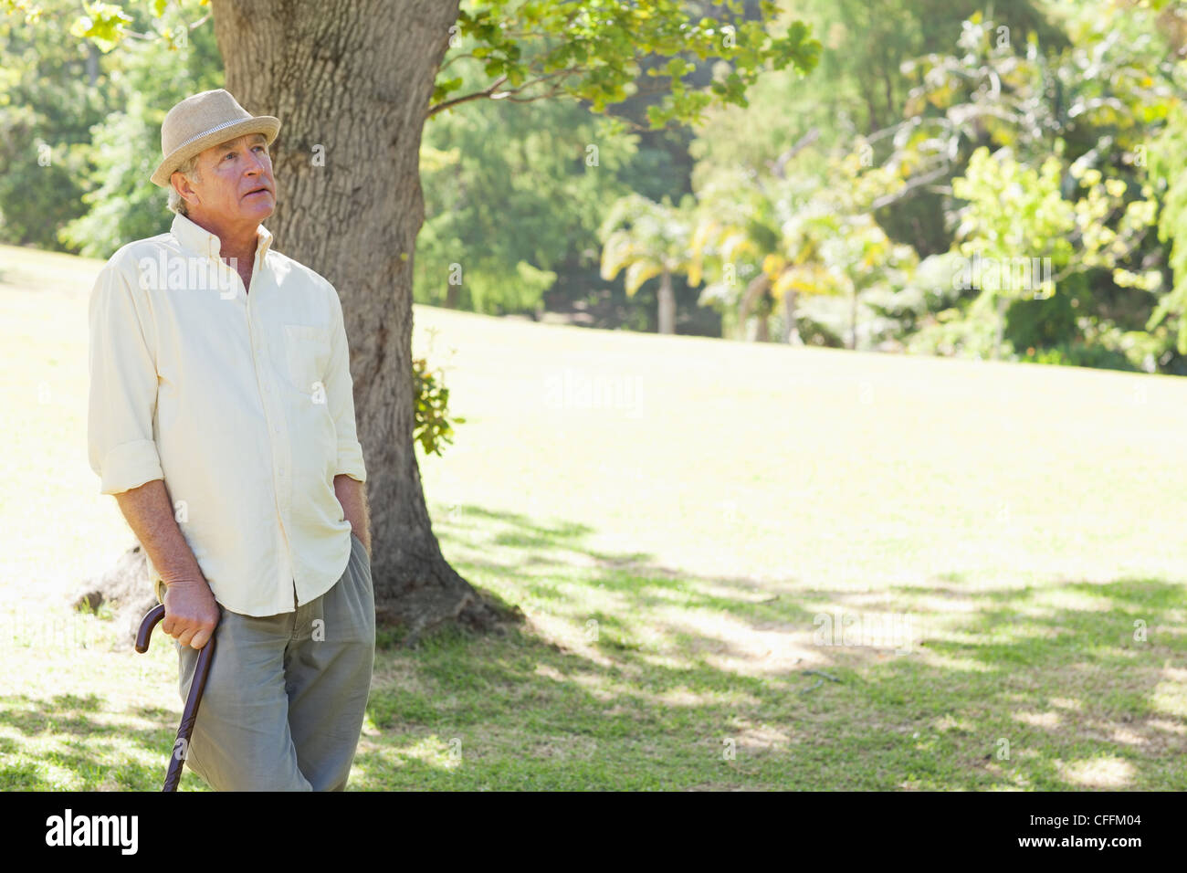 Man holding a cane while looking upwards Stock Photo