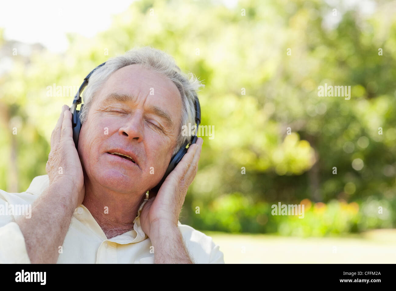 Man with his eyes closed thoughtfully listening to music Stock Photo