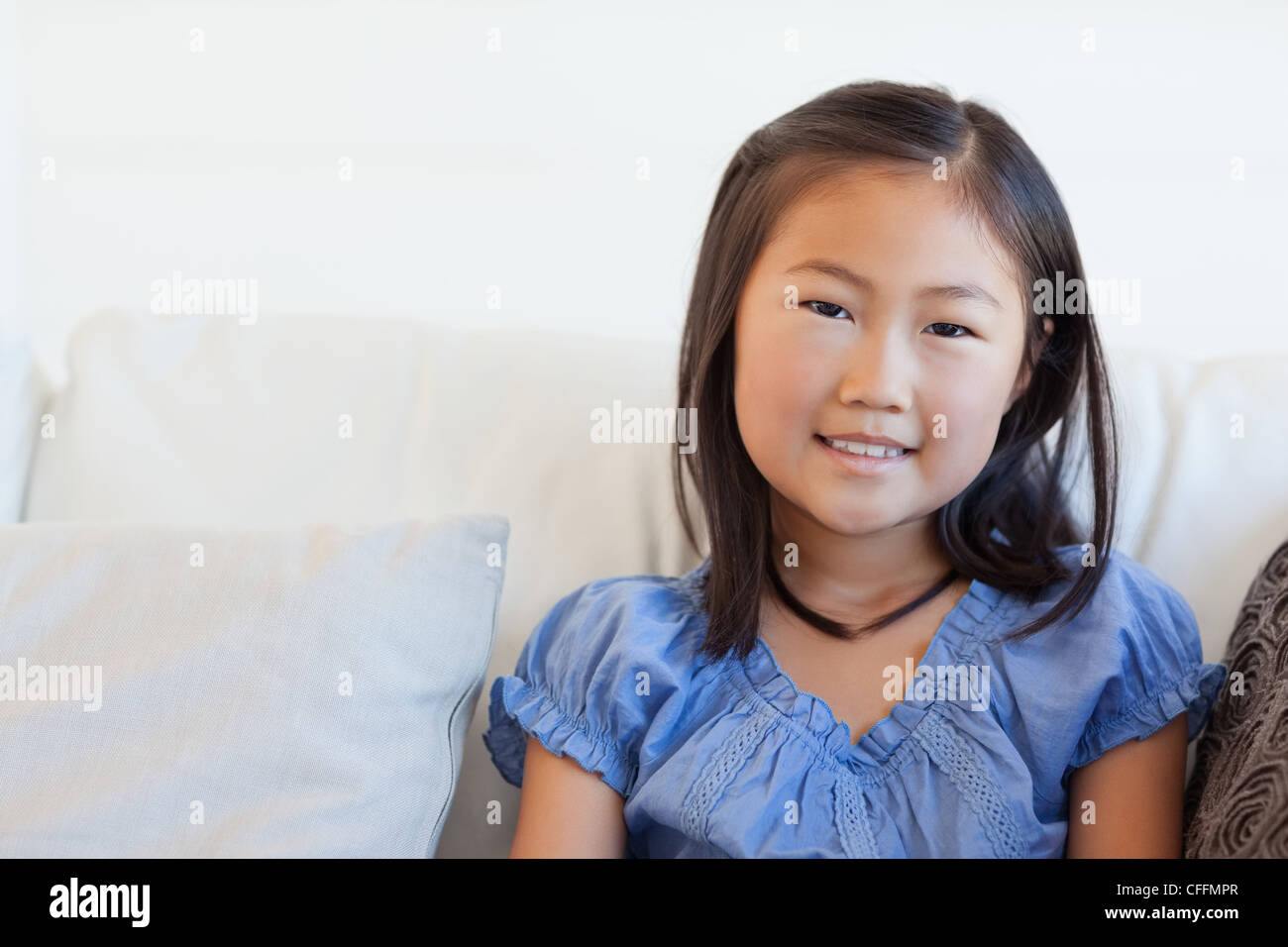 Portrait shot, girl sitting on the couch smiling Stock Photo - Alamy