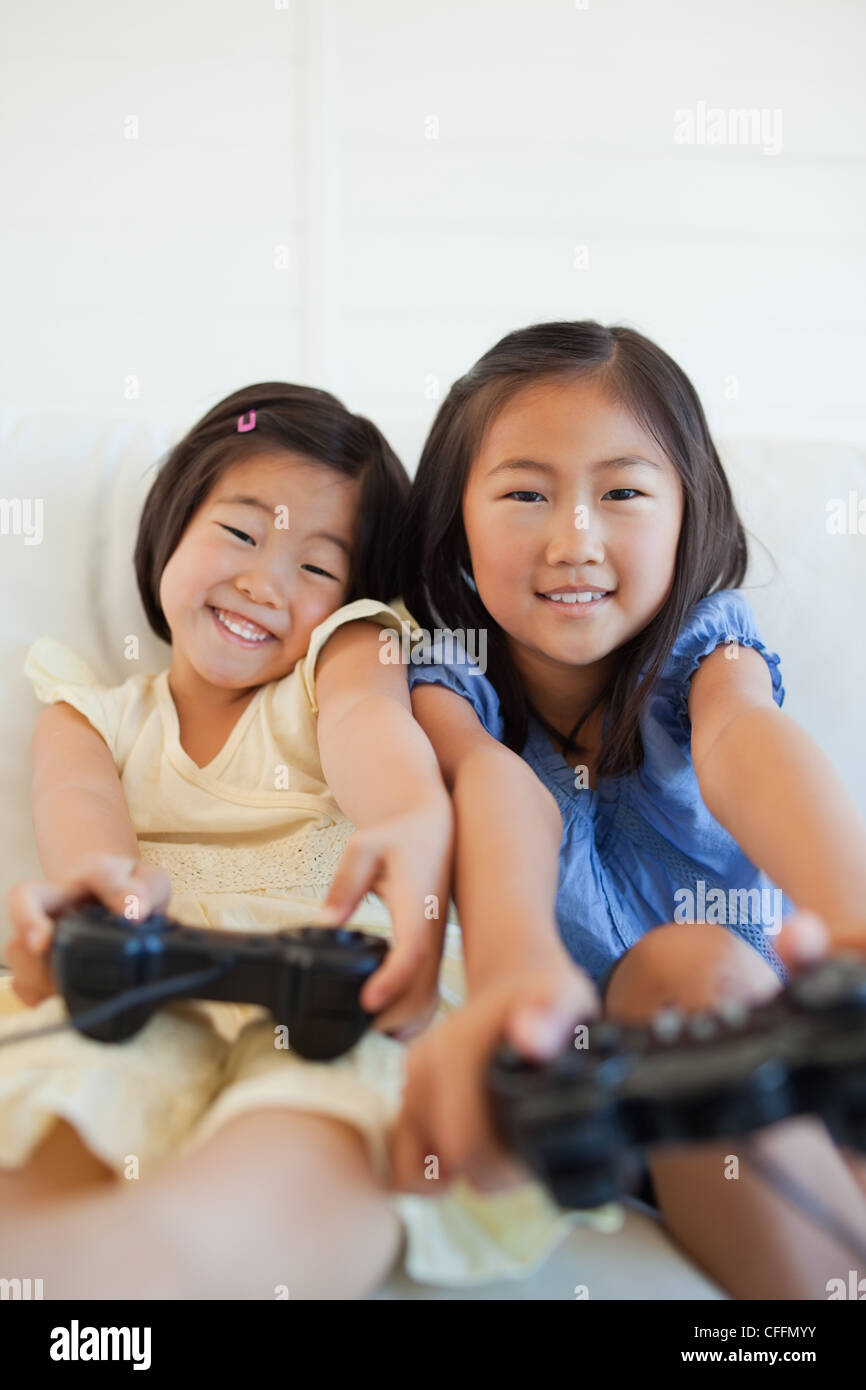 Close up of two sisters with controllers in their hands while playing a game Stock Photo