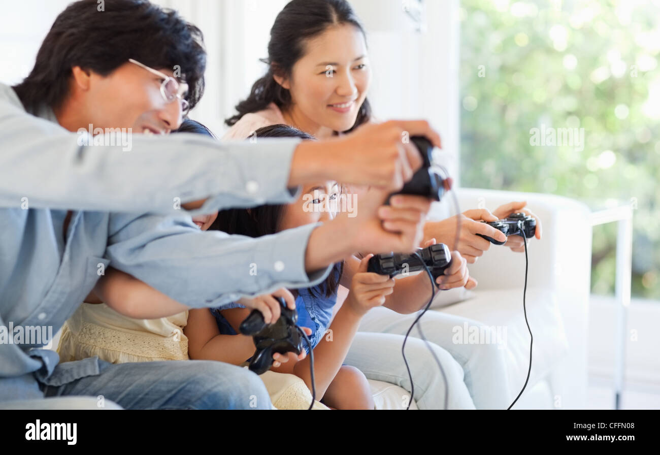 Family playing the same game together with controllers Stock Photo
