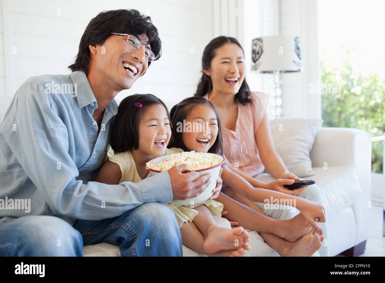 Happy family watching tv together on the couch Stock Photo - Alamy