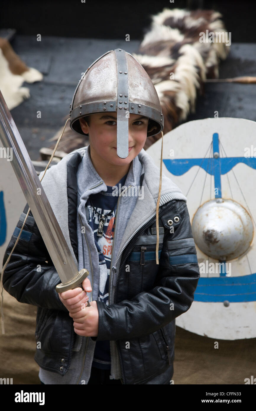 Boy dressed up as a viking warrior with sword, helmet and shield outside the Jorvik Centre in York Stock Photo