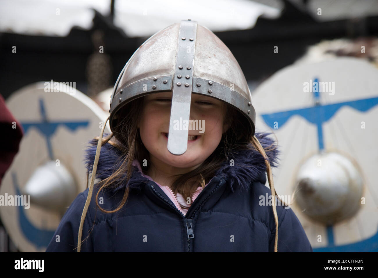 Girl dressed up as a viking warrior with sword, helmet and shield outside the Jorvik Centre in York Stock Photo