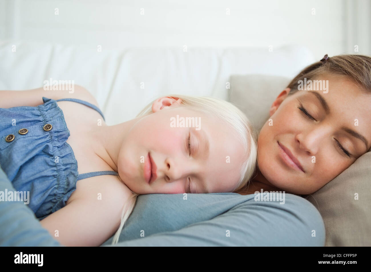 A mother and daughter calmly sleep on the couch Stock Photo Alamy