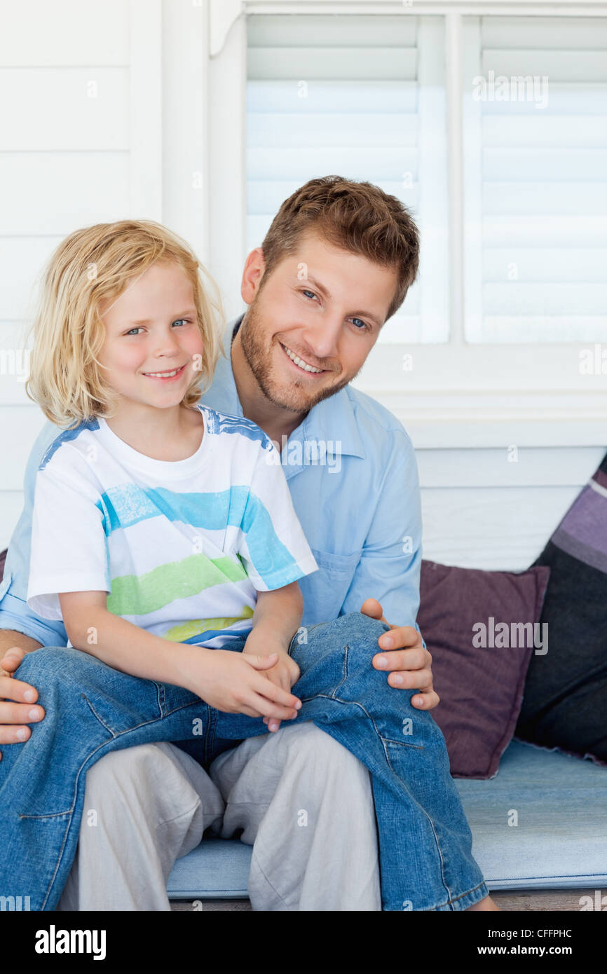 Father and his son sitting outside on the chair together Stock Photo ...