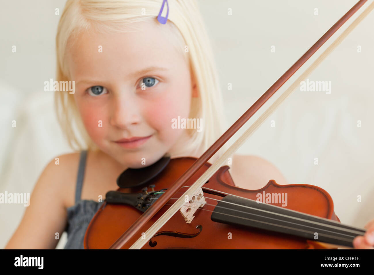 A girl looking ahead as she plays the musical instrument Stock Photo