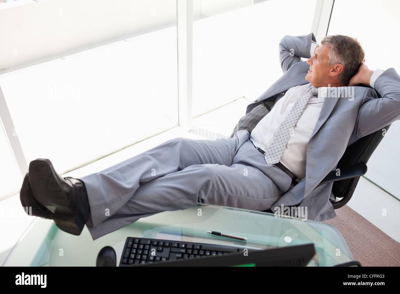 Boss at ease with feet on his desk Stock Photo - Alamy