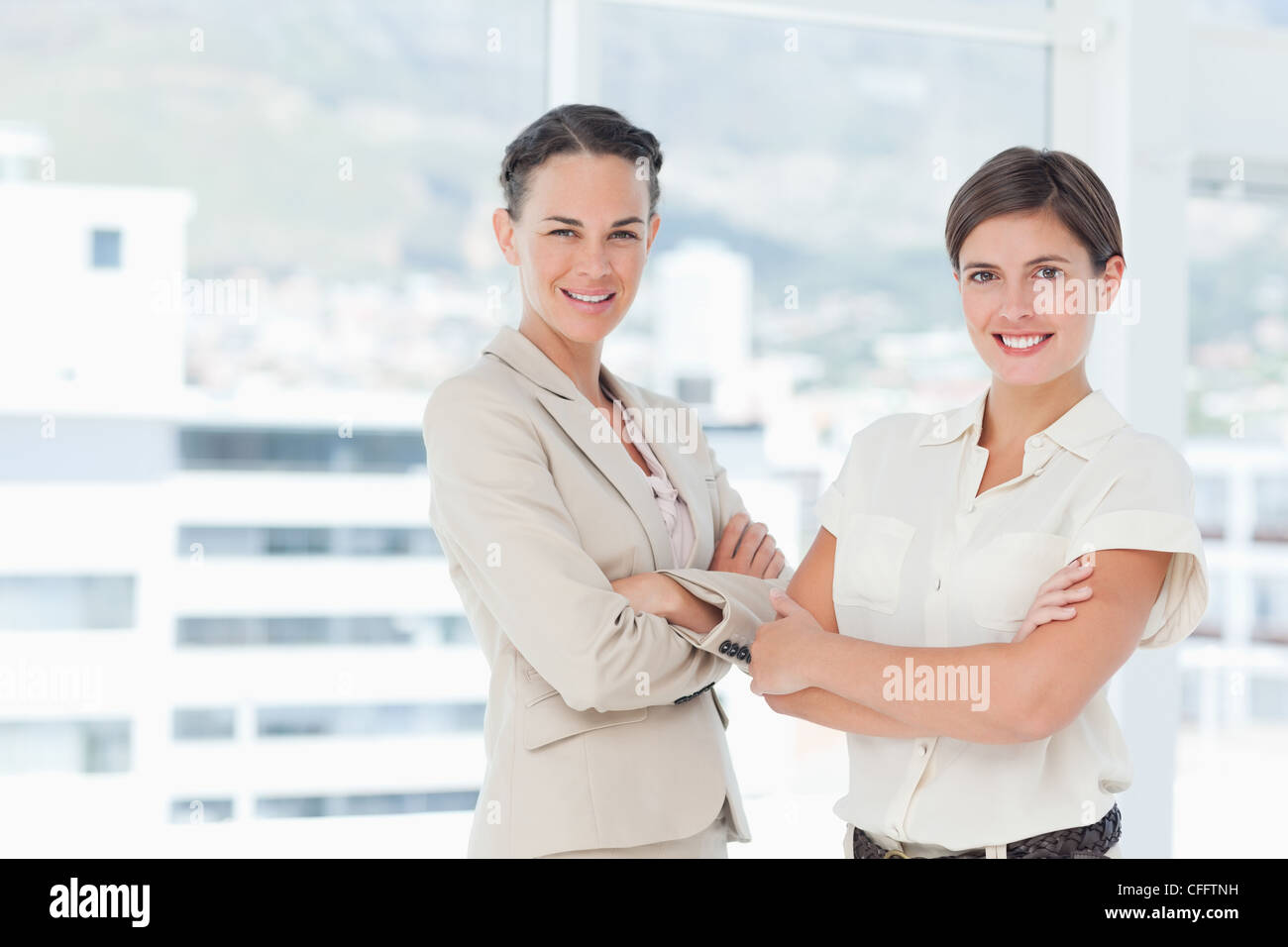 Smiling businesswomen with their arms folded Stock Photo