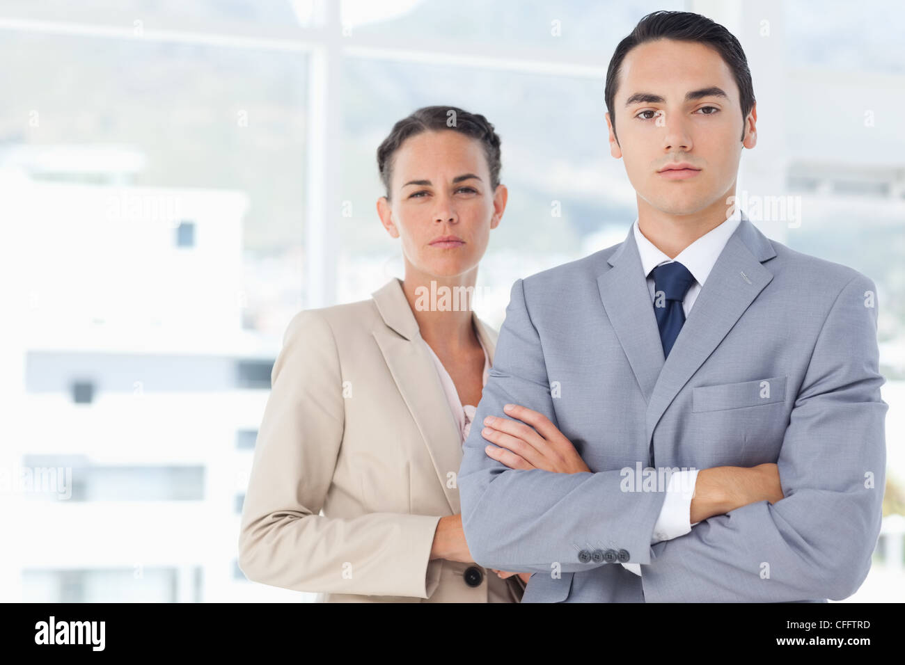 Confident businesspeople standing in front of a window Stock Photo