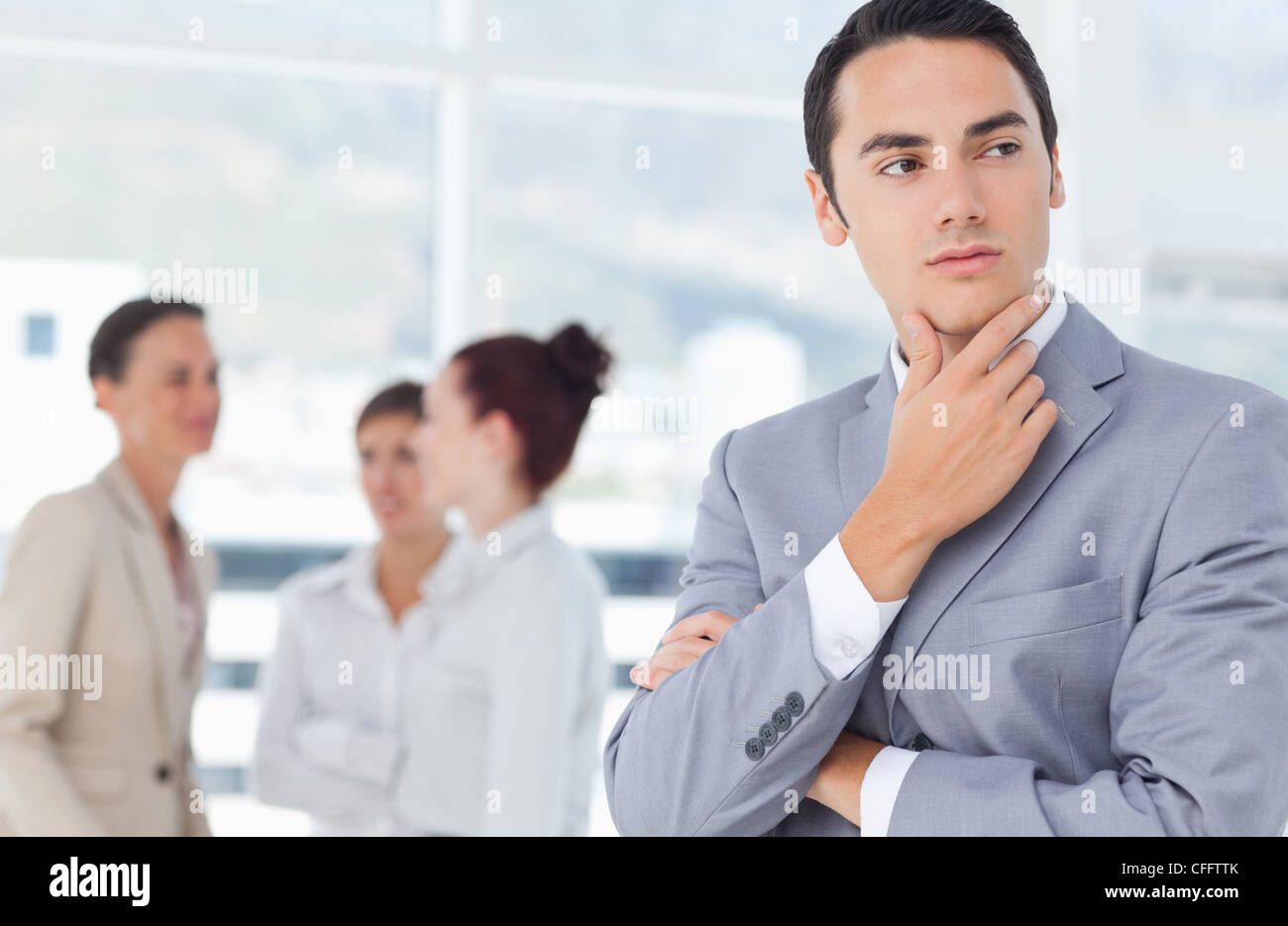 Thoughtful businessman with colleagues behind him Stock Photo