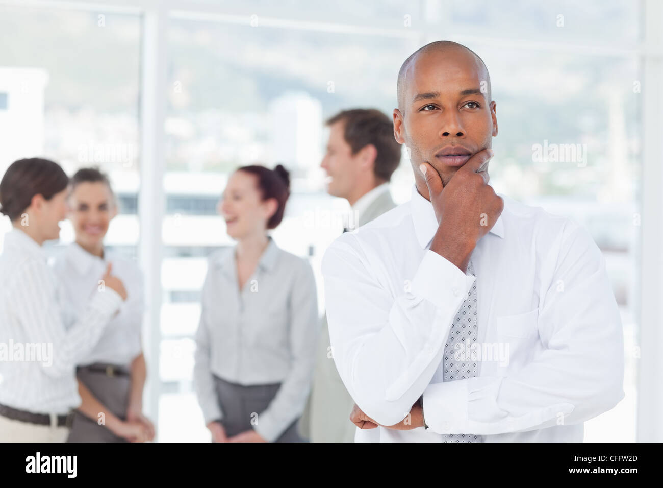 Thoughtful salesman with his associates behind him Stock Photo - Alamy