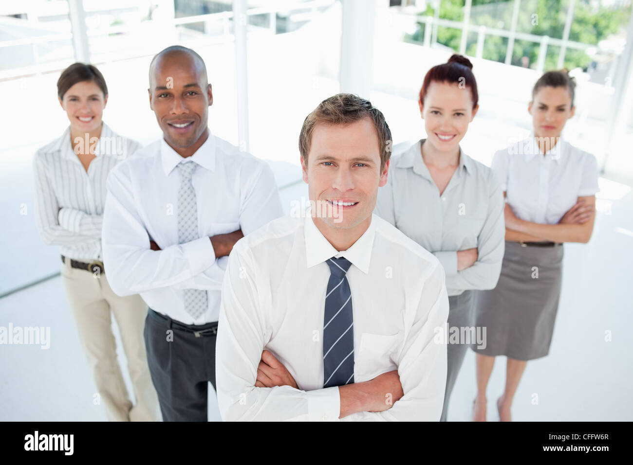 Salesteam with arms crossed standing together Stock Photo