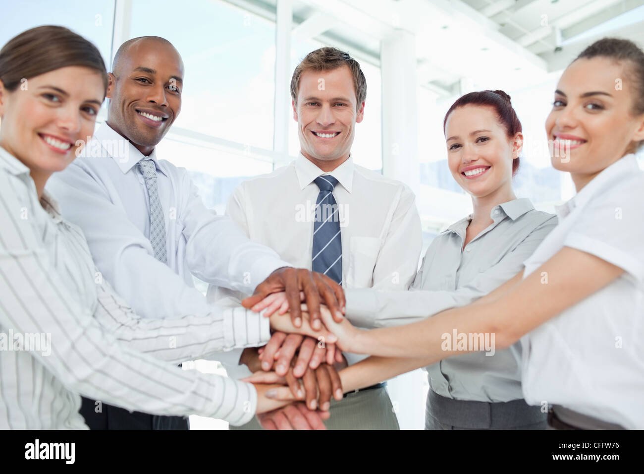 Smiling Business team doing teamwork gesture Stock Photo