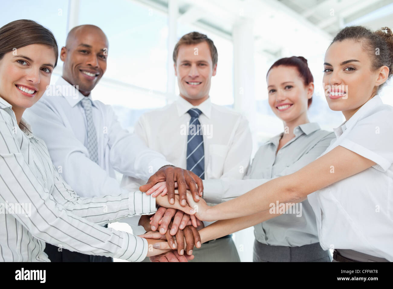 Smiling salesteam doing teamwork gesture Stock Photo