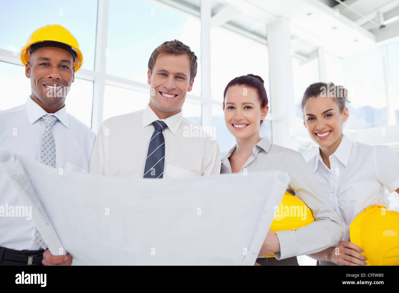 Smiling architects together with a building plan Stock Photo