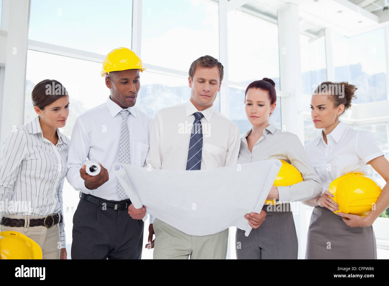 A group of architects reading off from some blueprints Stock Photo