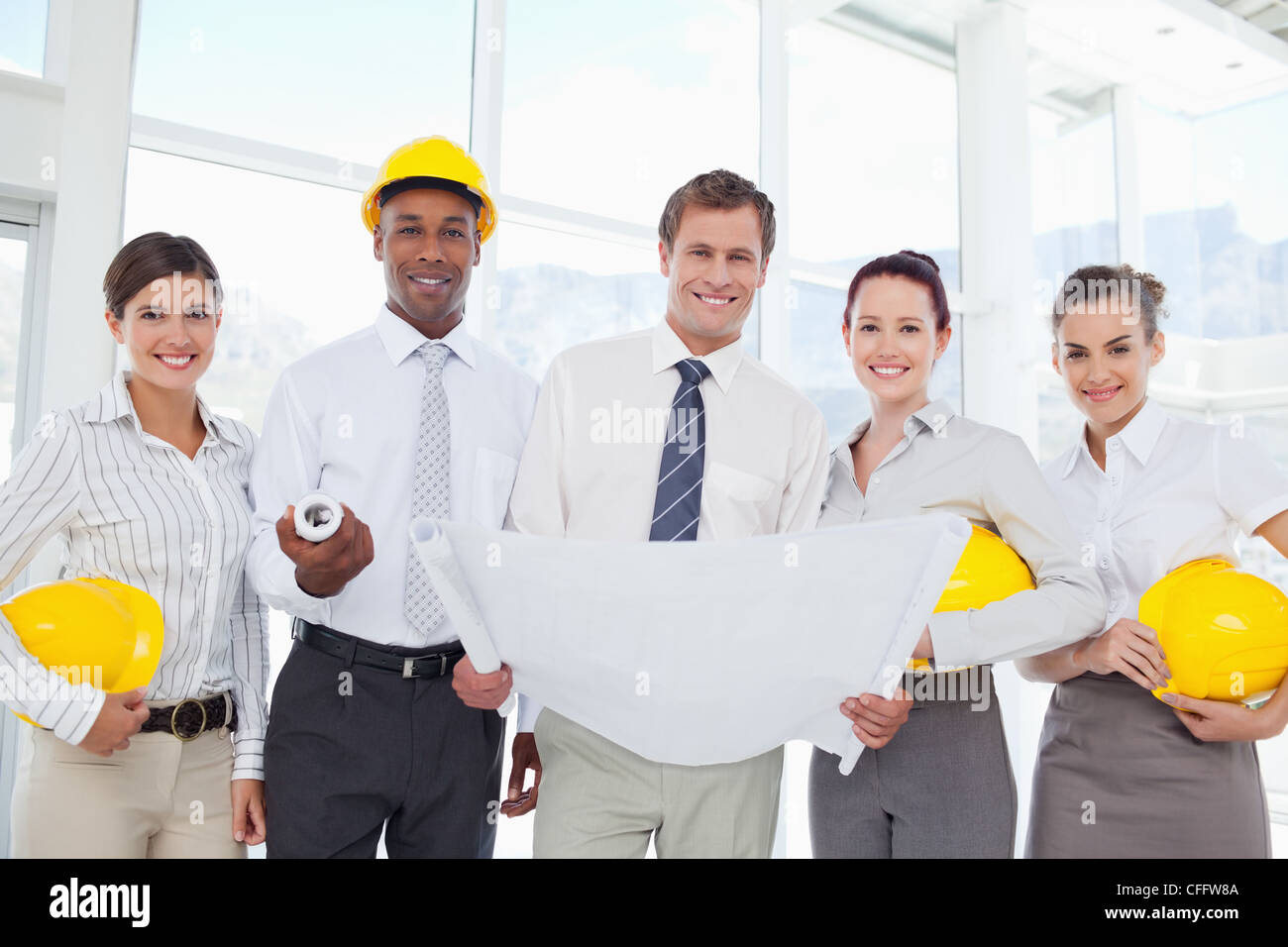 Smiling architects standing together with a blueprint Stock Photo
